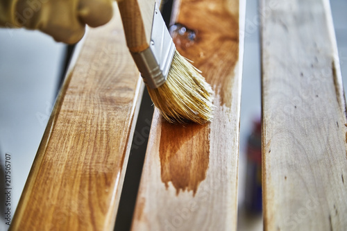 Paint Brush in a can of varnish in preparation to stain the wood slats