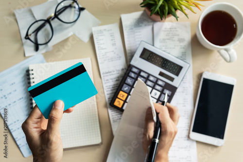 Young woman checking bills, taxes, bank account balance and calculating credit card expenses at home