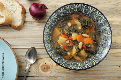 zuppa o minestra di pane con verdure su tavolo di legno