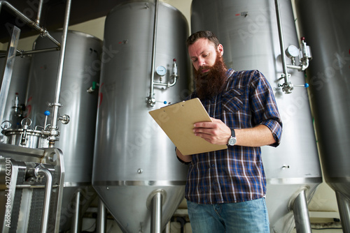 brewer monitoring brewing process at craft beer plant