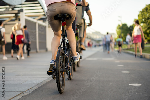 young wife and husband riding bikes in the europe street during summer season