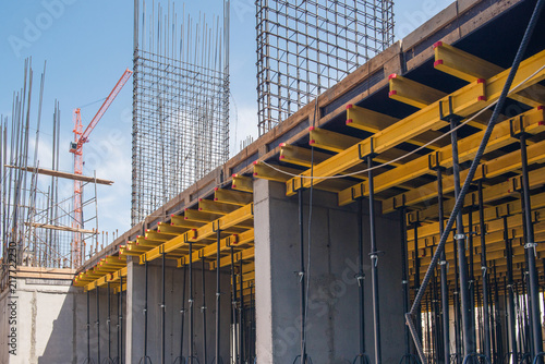 reinforced concrete structures of the building under construction. scaffolding and support. construction crane