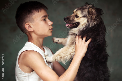 A young guy with a puppy looks at each other. Studio photo