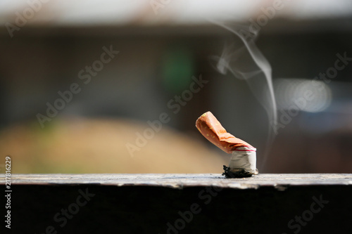 Brown color filter bottom cigarette on wooden floor.