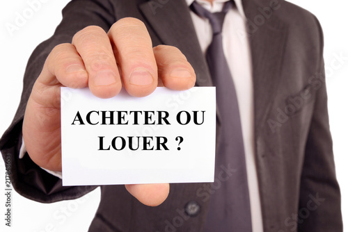 Homme tenant une carte sur laquelle est écrit acheter ou louer 