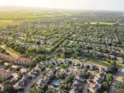 Top view urban sprawl in Dallas-Fort Worth area. Apartment building complex and suburban tightly packed homes neighborhood with driveways flyover. Vast suburbia subdivision in Irving, Texas, US