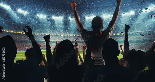Fans celebrating the success of their favorite sports team on the stands of the professional stadium while it's snowing