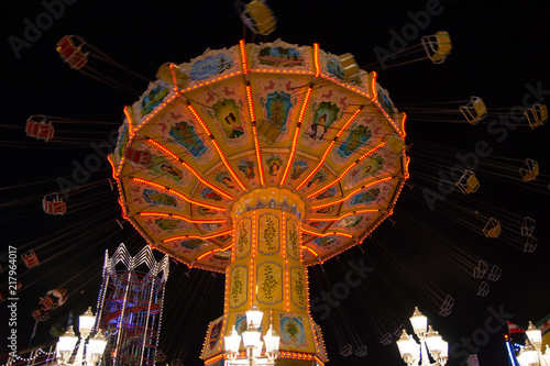 Fast ride on an illuminated chairoplane with high flying chairs 