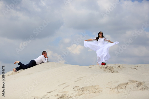 Ślub, wesele, młoda para na szczycie piaszczystej wydmy.