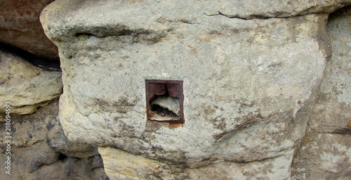 Tajemna skrytka, ze zniszczonymi metalowymi drzwiczkami na skalnej półce na wysokości