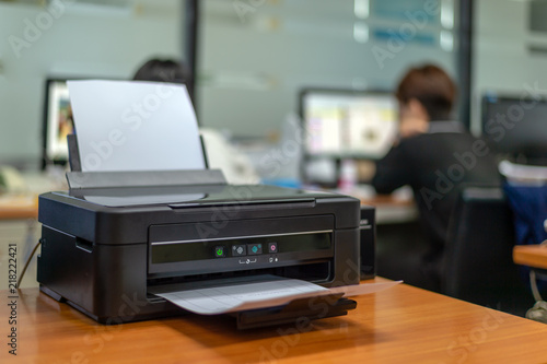 black printer in office with soft-focus and over light in the background