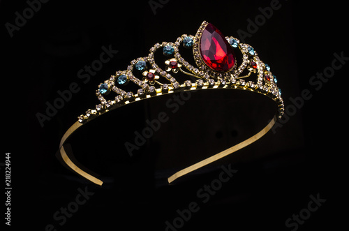 gold diadem with red ruby stone isolated on black