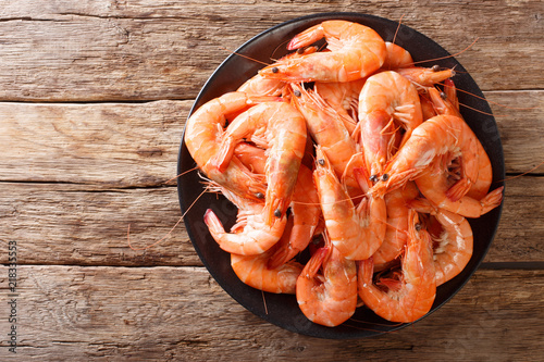 Healthy diet food: boiled wild tiger shrimps close-up on a plate on a table. Horizontal top view