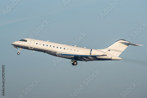 White modern private business jet taking off.