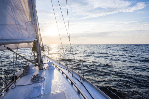 Sailing at sunset. A view from the yacht's deck to the bow and sails. Baltic sea, Latvia