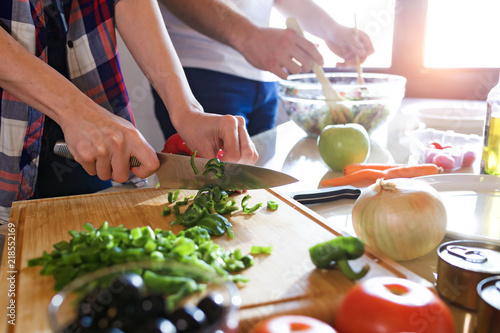 Young couple cooking together in the kitchen at home.