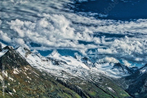 Alpy austriackie w Tyrolu, wędrówka szlakami górskimi, widok na dolinę alpejską i stoki pokryte śniegiem