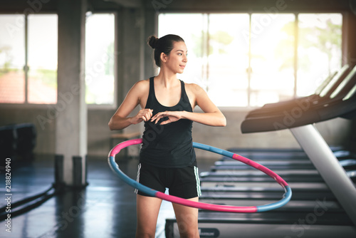 Sport Woman Exercising with a Hula Hoop in Gym - Lifestyle and Healthcare Concept