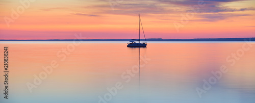 The world at rest - sailing boat in calm lake at sunset