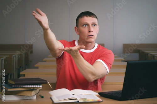 The student is sitting at the table and is looking for excuses for not being ready for the lesson.