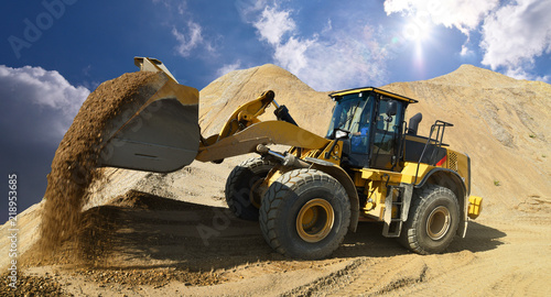 Wheel loader in a gravel pit during mining - heavy construction machine in open cast mining