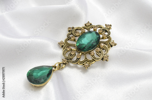 golden vintage brooch with emeralds on silk