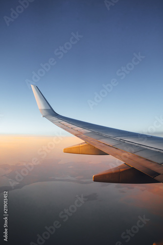 airplane wing against sunset sky background
