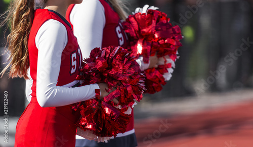 Two cheerleaders with red and white pom poms