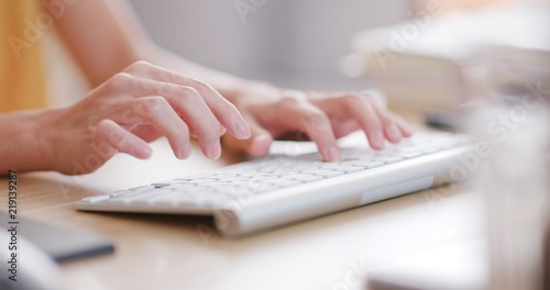 Woman typing on computer keyboard