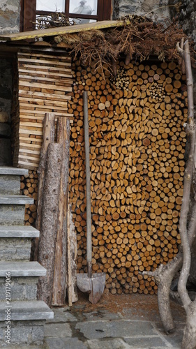 Ułożona sterta drewna na opał w drewutni.