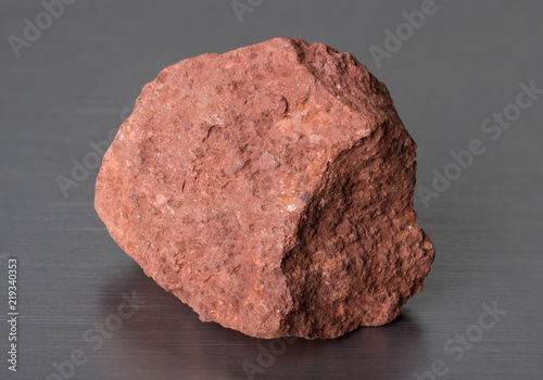 Specimen of mineral stone bauxite on gray background. Bauxite ore is the main source of aluminium. 