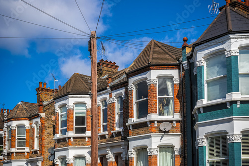 A row of typical British terraced houses in London with a telephone pole
