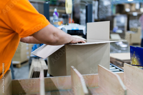 Close up shot of worker's hand preparing carton for printing in a modern printing house.