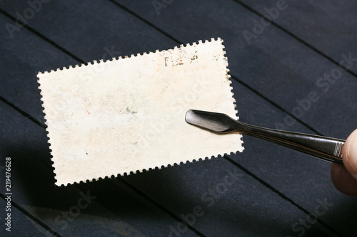 tongs keeps postage stamp with unused back side