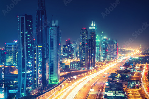 Scenic nighttime skyline of downtown Dubai, United Arab Emirates. Aerial view on highways and skyscrapers in the distance.