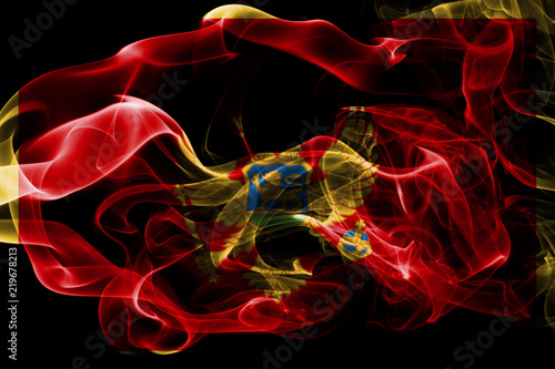 National flag of Montenegro made from colored smoke isolated on black background. Abstract silky wave background.
