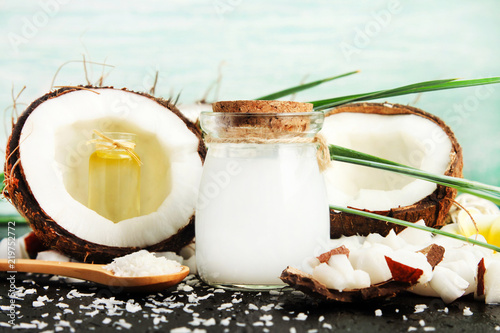 Coconut milk glass jar with nuts and oil bottles, fresh coconut flakes. Homemade skin & beauty care products rich in vitamins. 