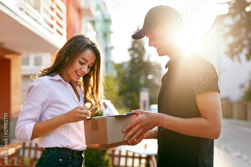 Courier Delivering Package To Woman, Client Signing Document