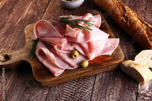 Sliced ham on wooden background. Fresh prosciutto. Pork ham sliced.