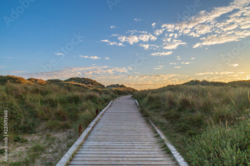 A wooden pathway leading towards the sea at Formby in Merseyside, taken at sunset