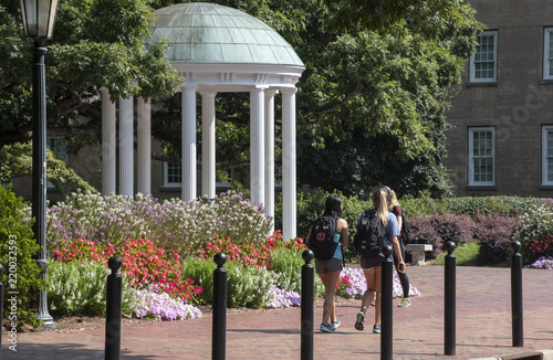 A small group of students walk past the Old Well at UNC Chapel Hill