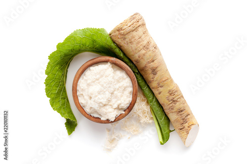 Fresh and grated horseradish in wooden bowl