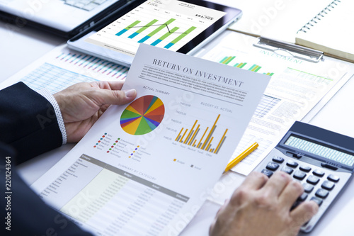 Businessman is deeply reviewing a financial report for a return on investment or investment risk analysis.