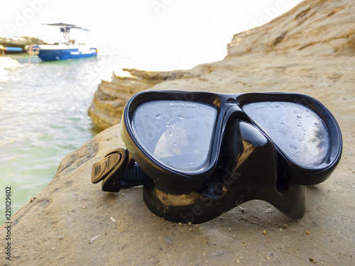 Diving mask for scuba diving on the rock near the sea
