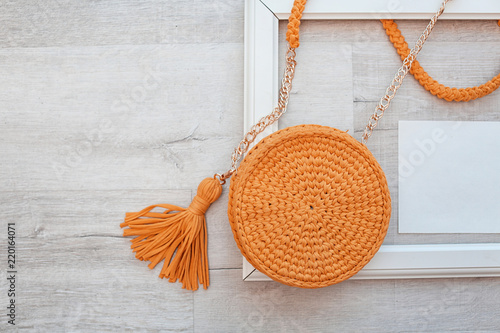 Flat lay composition with knitted bag and space for design on wooden background