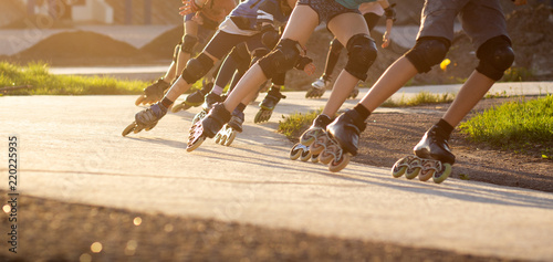 Group of teenagers skating on track in summer evening. Abstract panoramic short track speed skating sport background