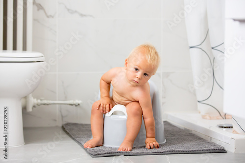 Child sitting on potty. Kid playing with educational toy and Toilet training concept. Baby learning, development steps.