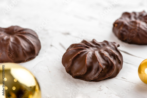 Three dark chocolate-coated zefir top view isolated on white background airy with christmas ornaments