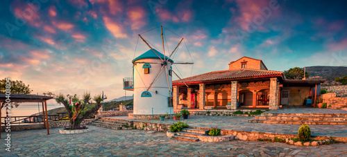 Picturesque morning scene of the countryside with windmill. Colorful spring sunrise on the Zakynthos island, Korithi location, Ionian Sea, Greece, Europe. Beauty of countryside concept background.