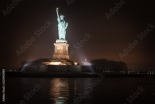 liberty statute in New York city at night, view from the new york water taxi